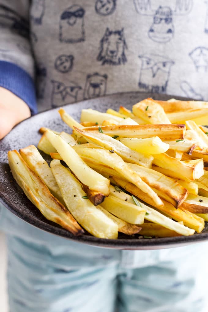 Child Holding a Plate of Roasted Parsnips