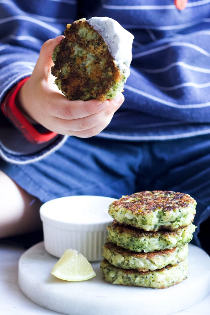 Child Holding Broccoli Fritter Dipped in Yoghurt Sauce