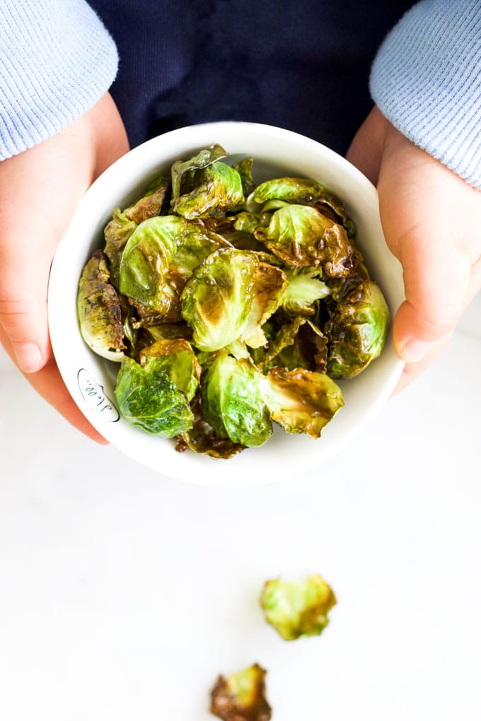 Child Holding Bowl of Brussels Sprouts Chips
