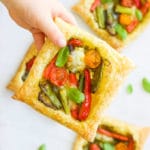 Child Holding a Puff Pastry Tart Filled with Roasted Vegetables