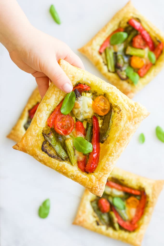 Child Holding a Puff Pastry Tart Filled with Roasted Vegetables