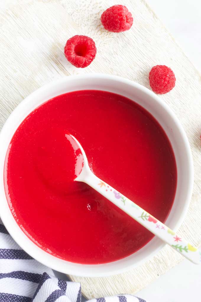 Raspberry Puree in Bowl with Raspberries Scattered