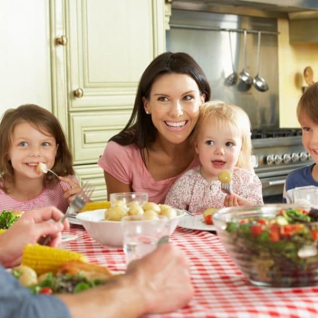 Family with Young Children Sitting at Table for Family Meal