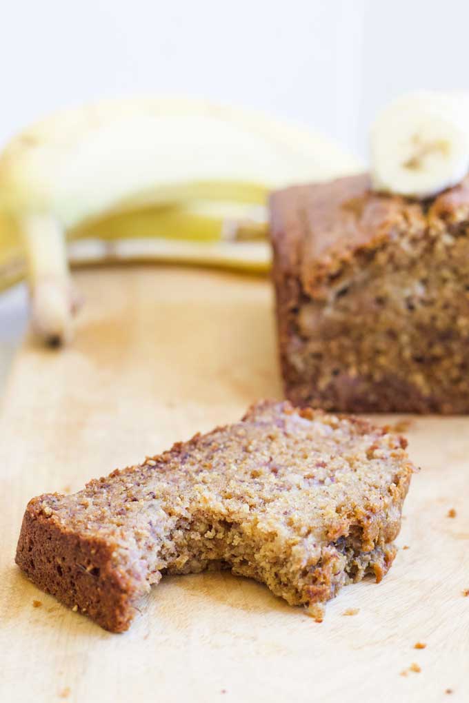 Slice of Banana Bread with Bite Removed and Loaf in Background