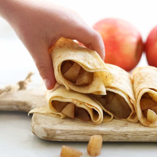Child Grabbing a Filled Apple Crepe from Stack