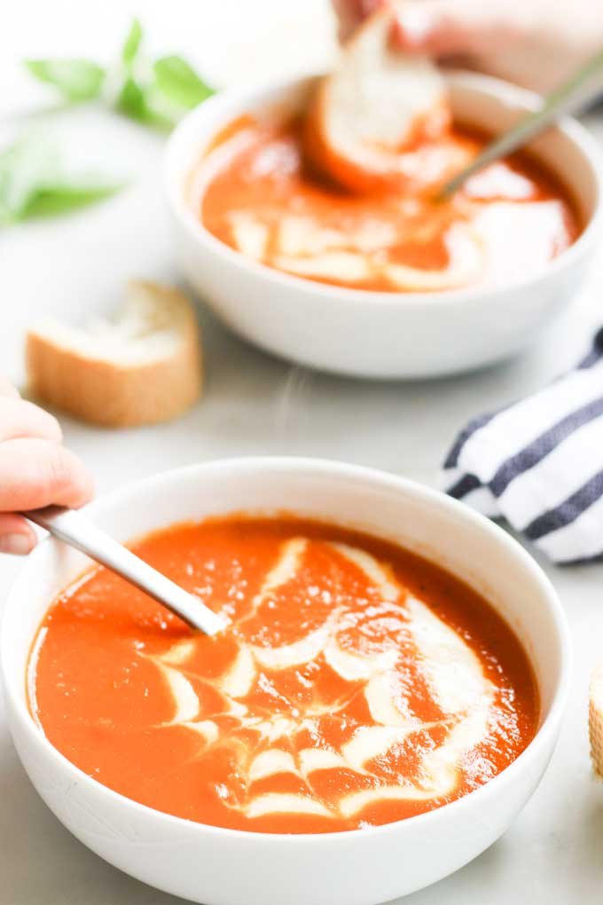 Child Taking a Spoon of Tomato Soup from Bowl