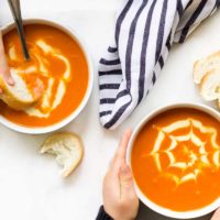 Top Down View of Two Children Eating Bowls of Tomato Soup
