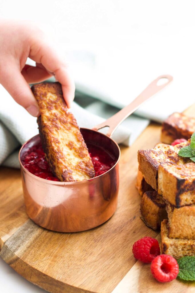 Child Dipping Eggy Bread Stick into Fruit Compote