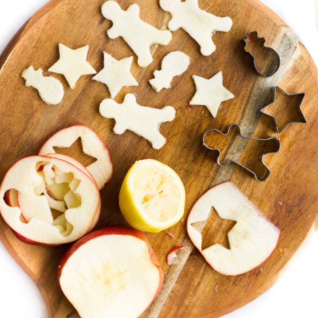 Chopping Board with Slices of Apple (with cookie cutter shapes cut out) and Lemon