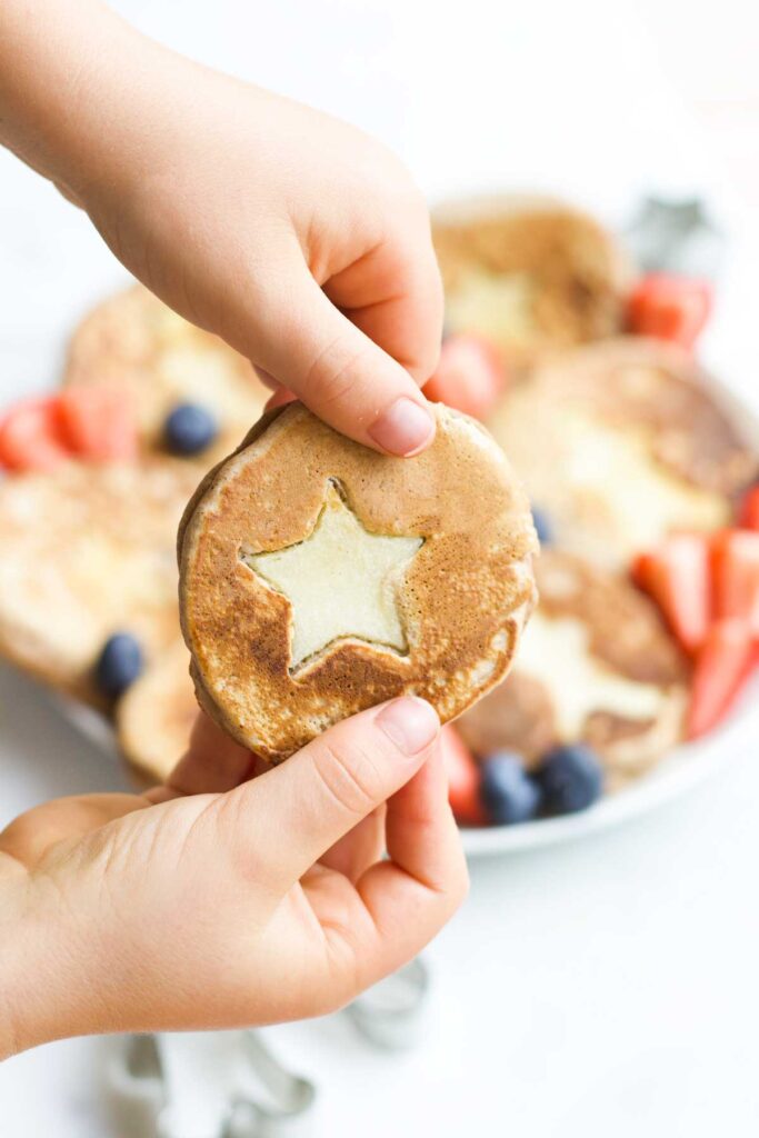 Child Holding Christmas Spiced Pancake with Star Apple Insert