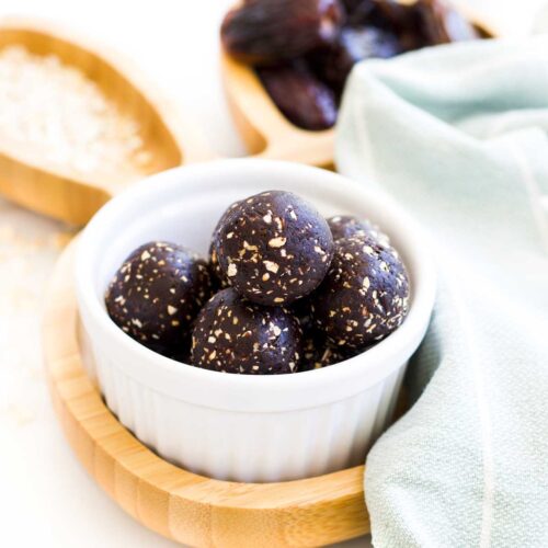 45 Degree Shot of cocoa Balls in White Bowl Sitting on Wooden Bunny Plate