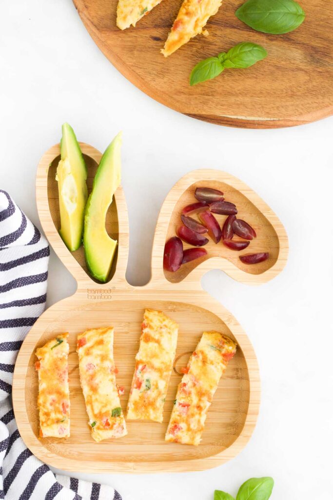 Top Down Shot of Omelette Fingers on Baby Bunny Plate Served with Avocado and Grapes