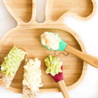 Baby Plate with Mashed Egg and Avocado on a Spoon and Spread on a Toast Finger.