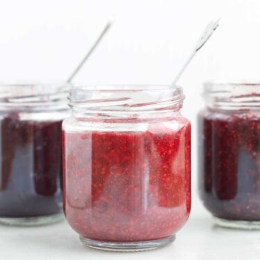 Three Varieties of Chia Seed Jam in Jars. Raspberry at The Front and Blueberry and Cherry in Background