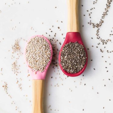 Top Down View of Two Spoons One with White Chia Seeds and One With Black Seeds