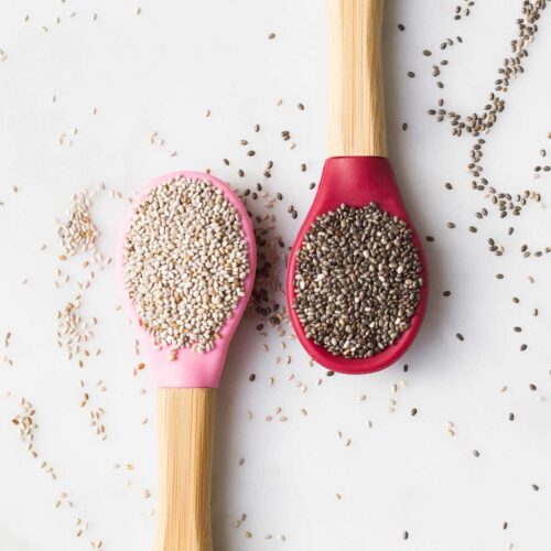 Top Down View of Two Spoons One with White Chia Seeds and One With Black Seeds
