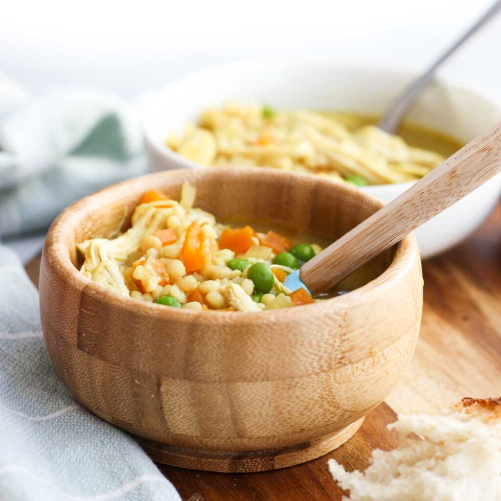 Side Shot of Chicken Soup in Toddler Bowl with Adult Bowl in Background