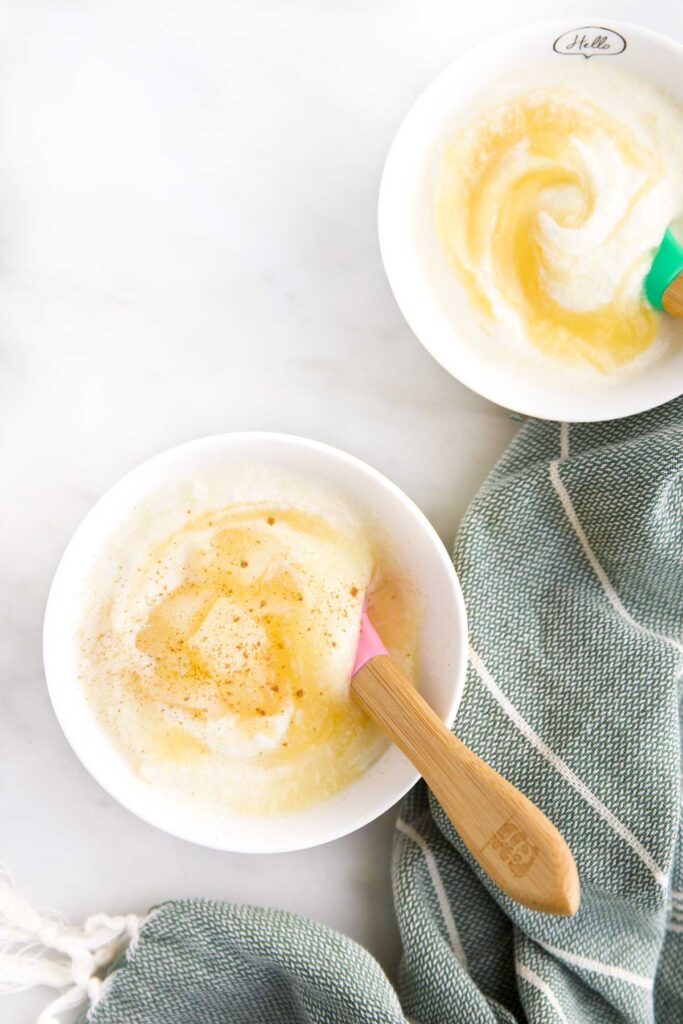 Top Down Photo of Two Bowls of Apple Yogurt in Small Bowls and Baby Spoons