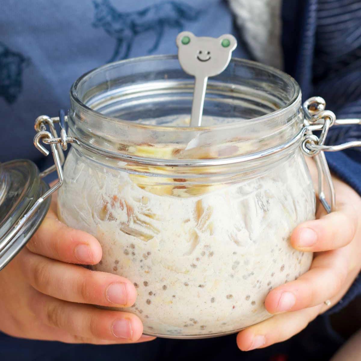 Child Holding A Jar of Apple Overnight Oats.