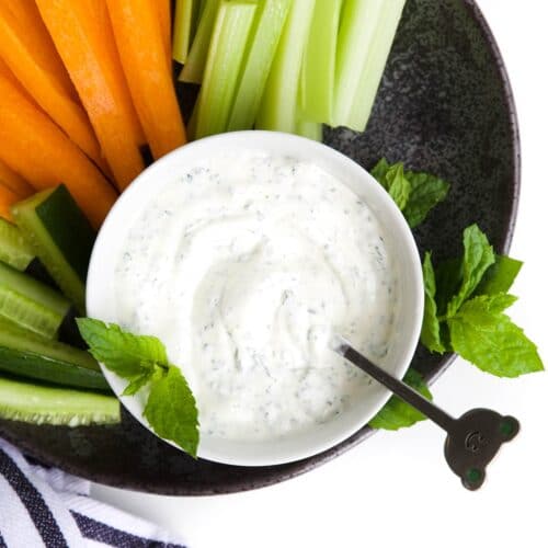 MInt Yogurt Sauce in Bowl Sitting on Plate with Cut Vegetable Sticks
