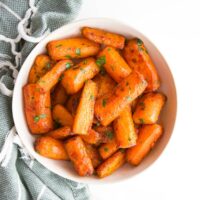Air Fryer Carrot Chunks in White Bowl with Green Napkin in Background