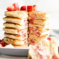 Stack of Strawberry Pancakes with Wedge Cut Out to Show The Inside of the Pancakes