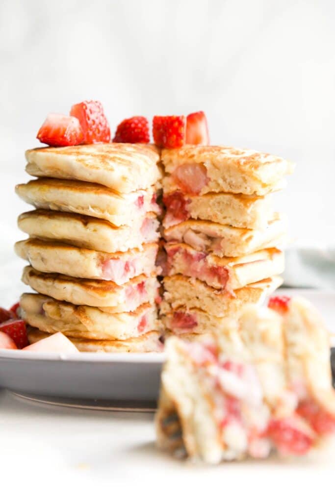Stack of Strawberry Pancakes with Wedge Cut Out to Show The Inside of the Pancakes