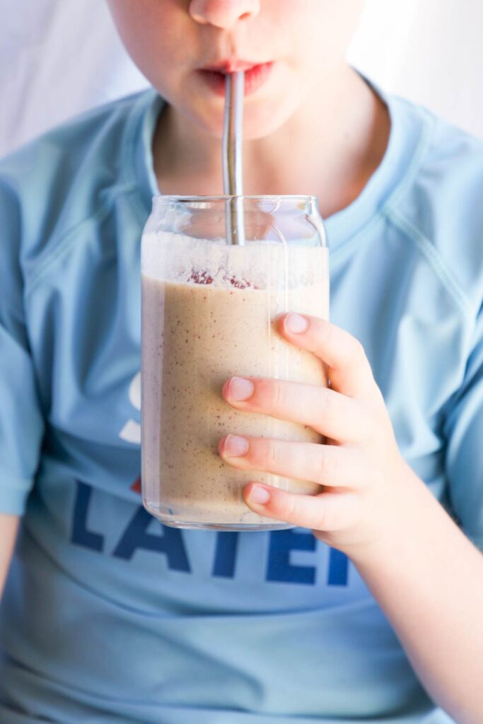 Child Drinking Peach and Banana Smoothie from Glass
