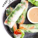 Vegetable Rice Paper Rolls on Black Plate with Peanut Dipping Sauce. Text Overlay "Veggie Rice Paper Rolls WIth a Peanut Dipping Sauce"