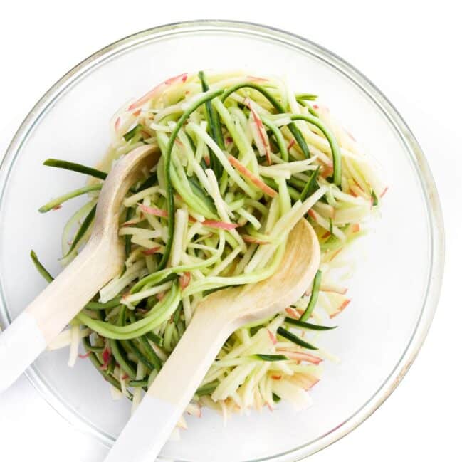 Cucumber and Apple Salad in Glass Bowl with Salad Serving Spoons