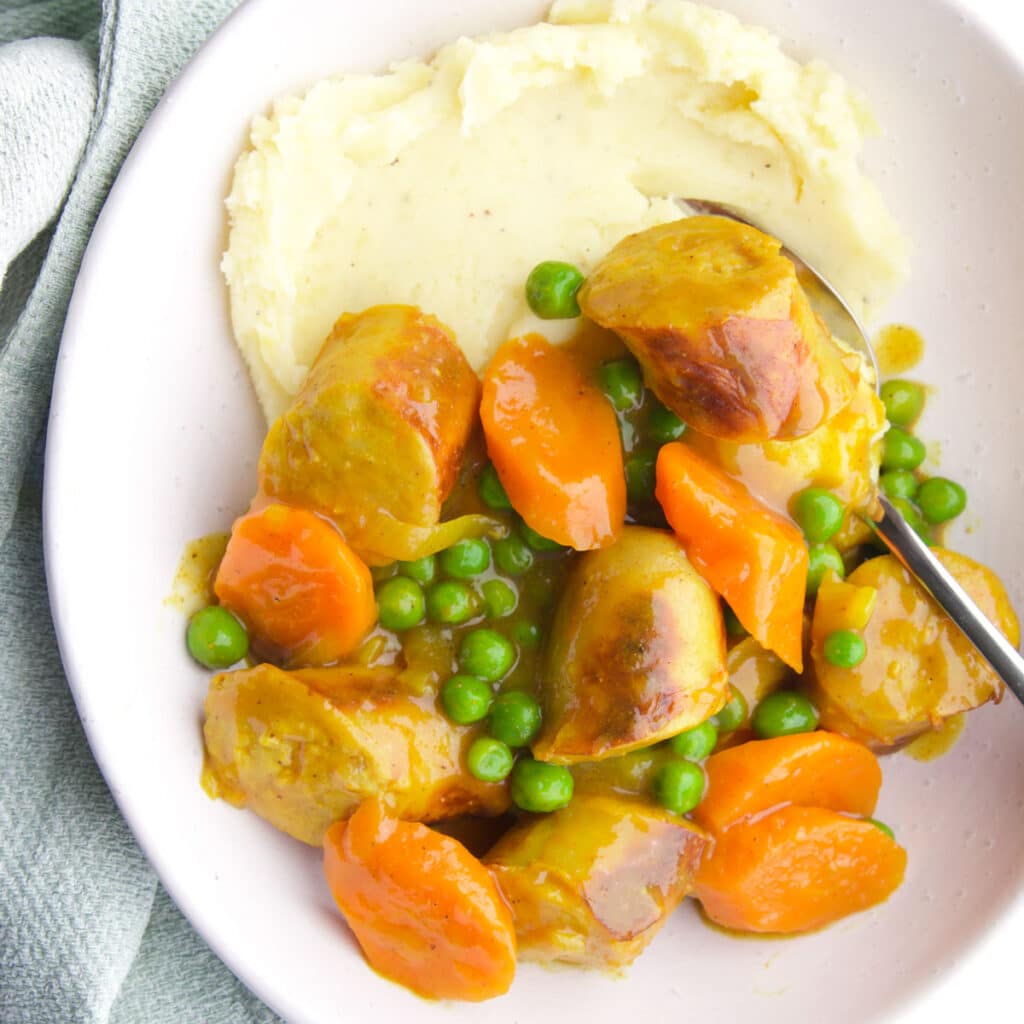 Mashed Potato and Curries Sausages in White Bowl.