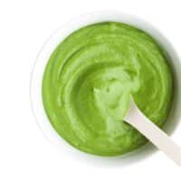 Green Bean Puree in White Bowl With White Spoon.