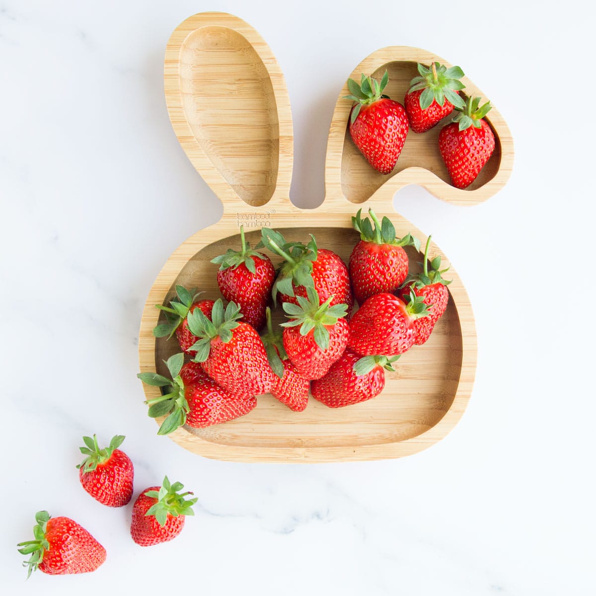 Whole Strawberries on Bunny Shaped Baby Bamboo Plate. 