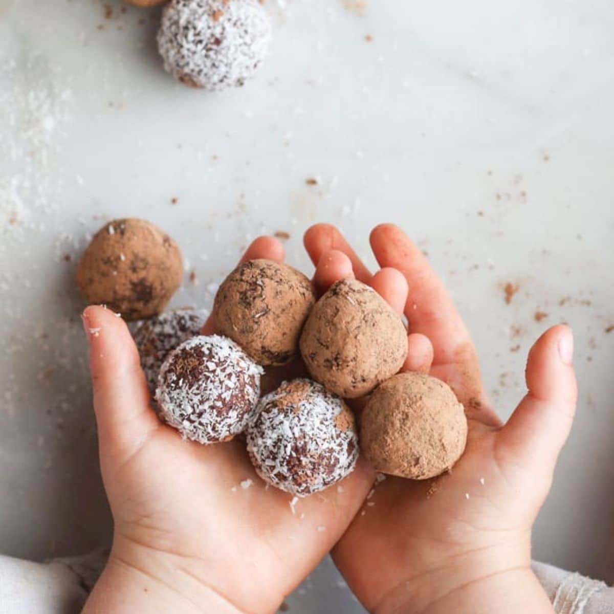 Child's Hands Holding Several Cherry Bliss Balls.