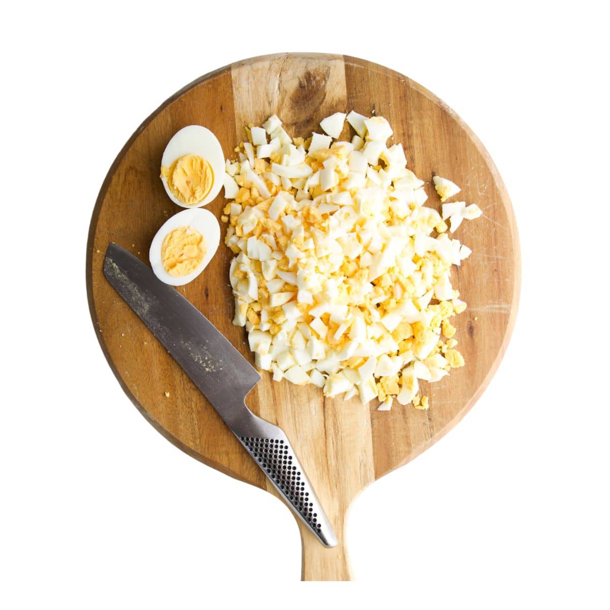 Hard Boiled Eggs Cut into Small Pieces on Wooden Choppingboard.