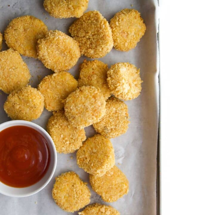 Homemade Chicken Nuggets on Baking Sheet with Bowl of Ketchup.