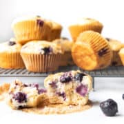 Greek Yogurt Blueberry Muffin Spit Open With More Muffins in Background.